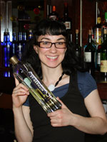 Laura with a bottle of St. Germain at the bar at Mambu